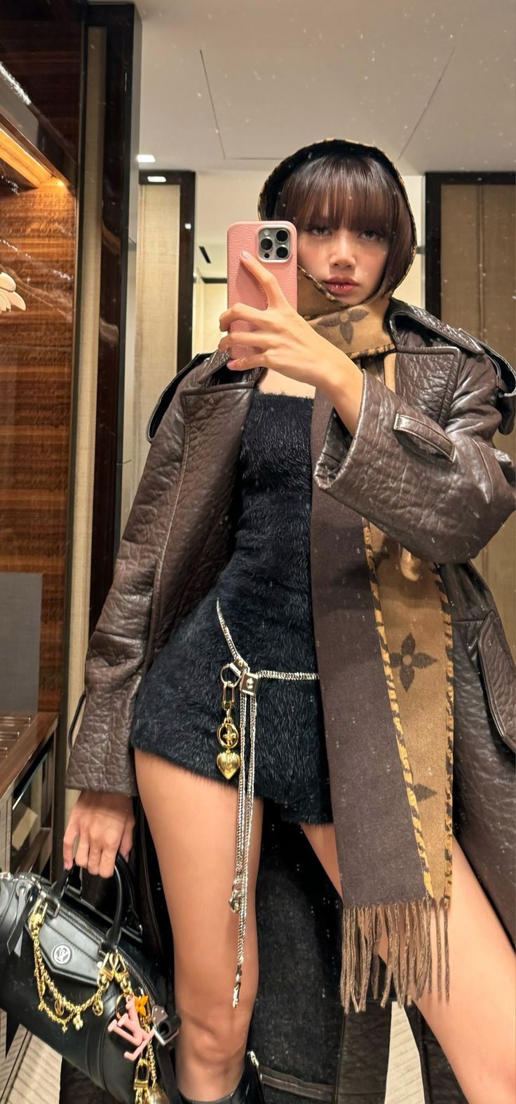 a woman taking a selfie with her cell phone in the mirror while wearing thigh high boots