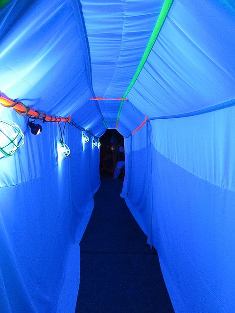 the inside of a blue tent with white walls and lights on it's sides