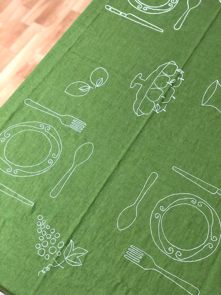 a green table cloth with white drawings on it