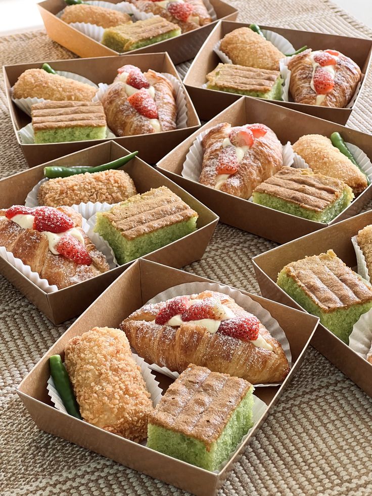 several boxes filled with different types of pastries on top of a carpeted floor