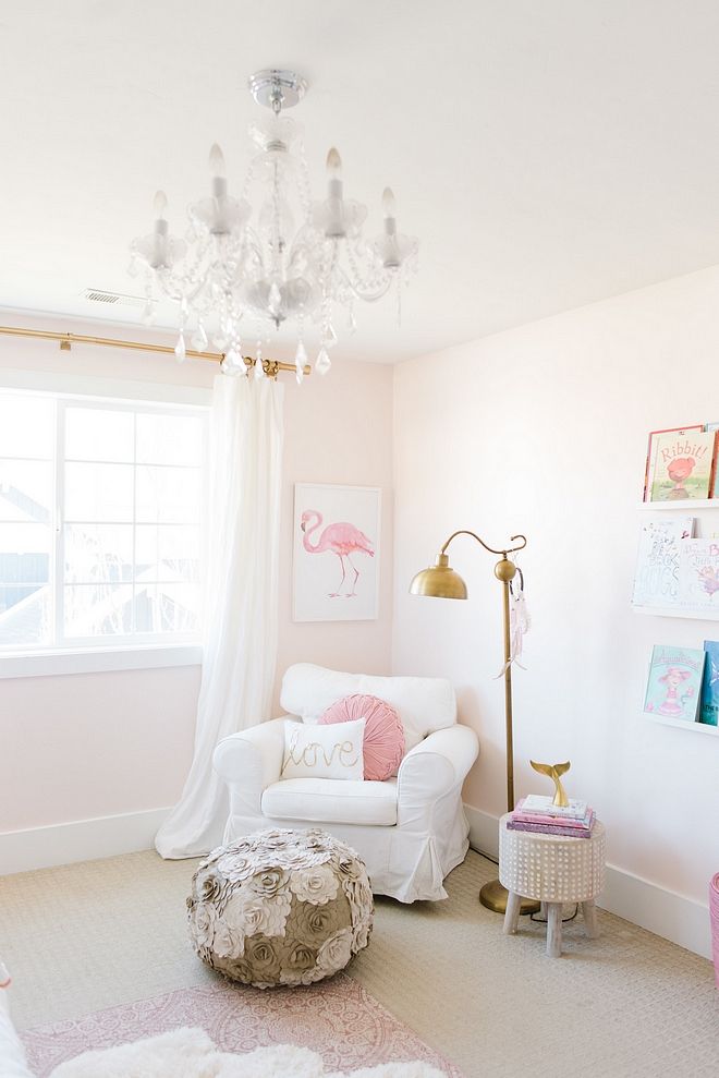 a living room filled with furniture and a chandelier hanging from the ceiling over a window