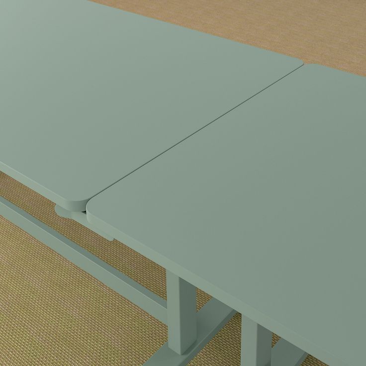 a table with two legs sitting on top of a carpeted floor next to a wall