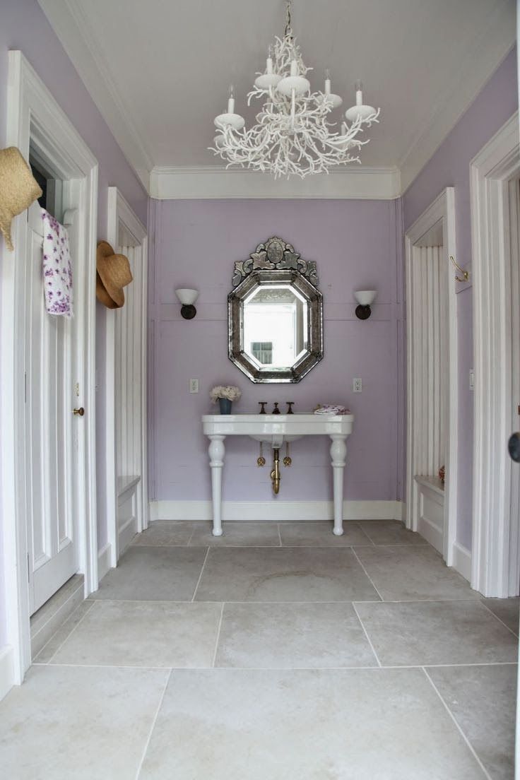 a white sink sitting under a mirror next to a chandelier in a bathroom