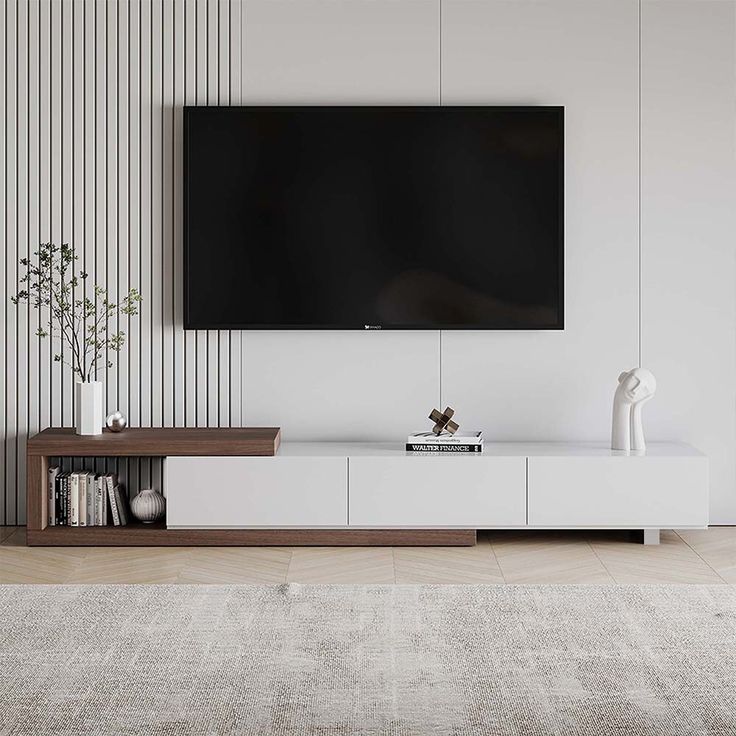 a flat screen tv mounted to the side of a white wall in a living room