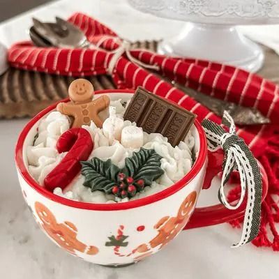 a red and white christmas mug filled with hot chocolate, marshmallows and candy canes