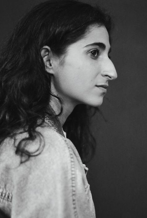 a black and white photo of a woman with long hair looking off to the side