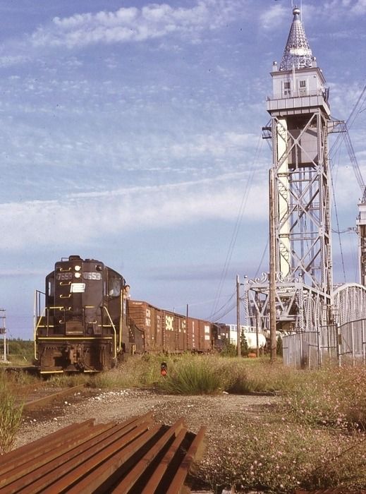 a train traveling down tracks next to a tall tower