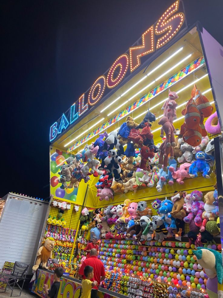 a carnival booth filled with lots of stuffed animals