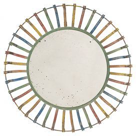 a circular mirror with multicolored sticks on it's sides and a white background