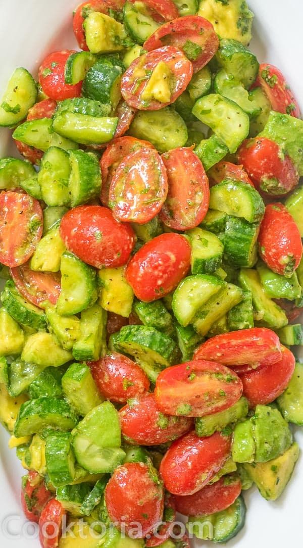 a white bowl filled with cucumbers and tomatoes