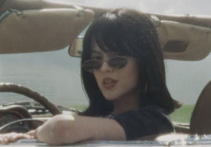 a woman sitting in the driver's seat of a car