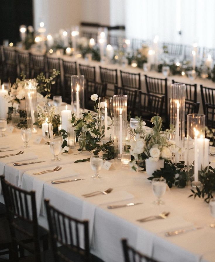 a long table is set with candles and flowers for a formal dinner or wedding reception