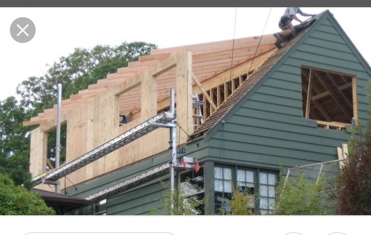 two men working on the roof of a house