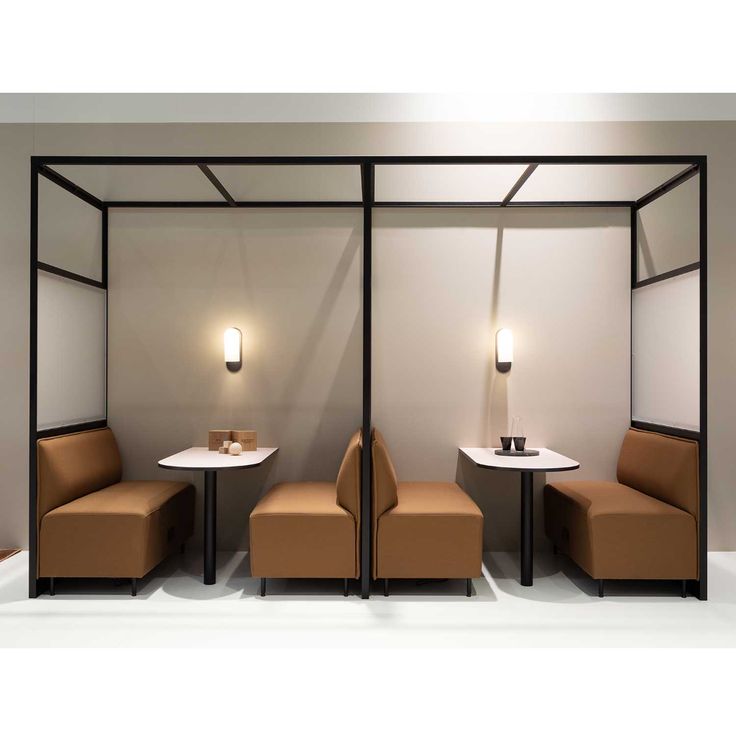 two chairs and a table in a room with lights on the wall behind them,