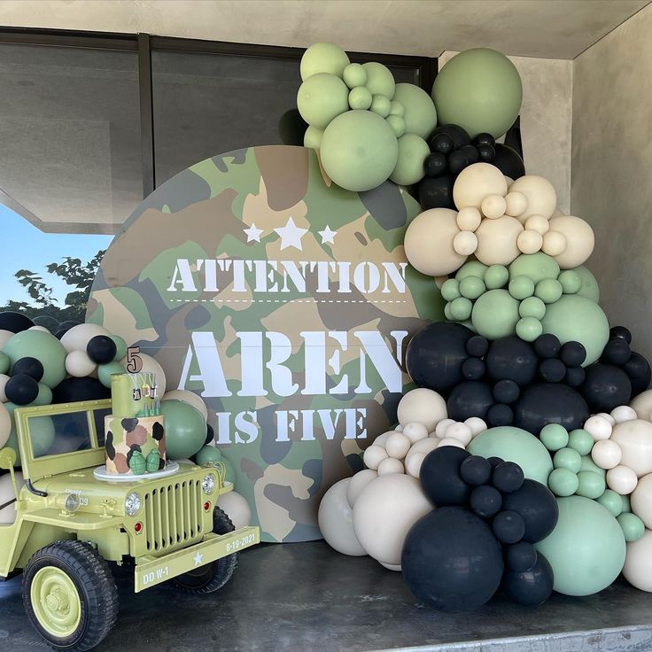 an army themed birthday party with balloons and balloon decorations on the back of a jeep