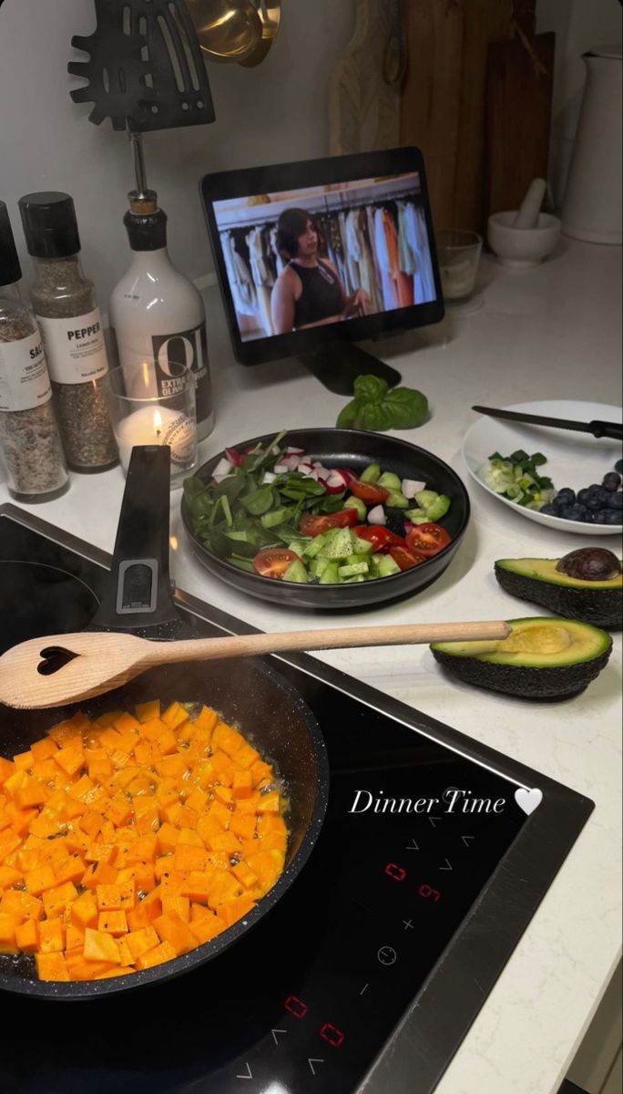 a pan filled with food sitting on top of a stove next to a plate of vegetables