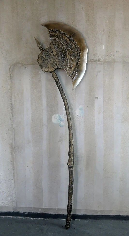 a large metal flower on top of a wooden stick in front of a white wall