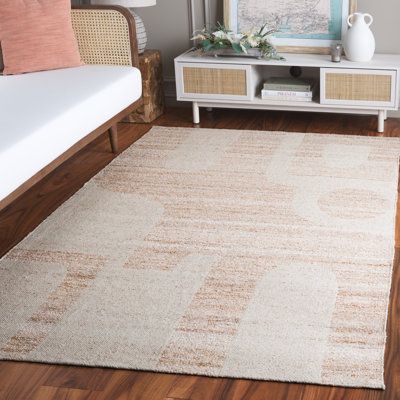 a living room with a couch, coffee table and rug on the hardwood flooring