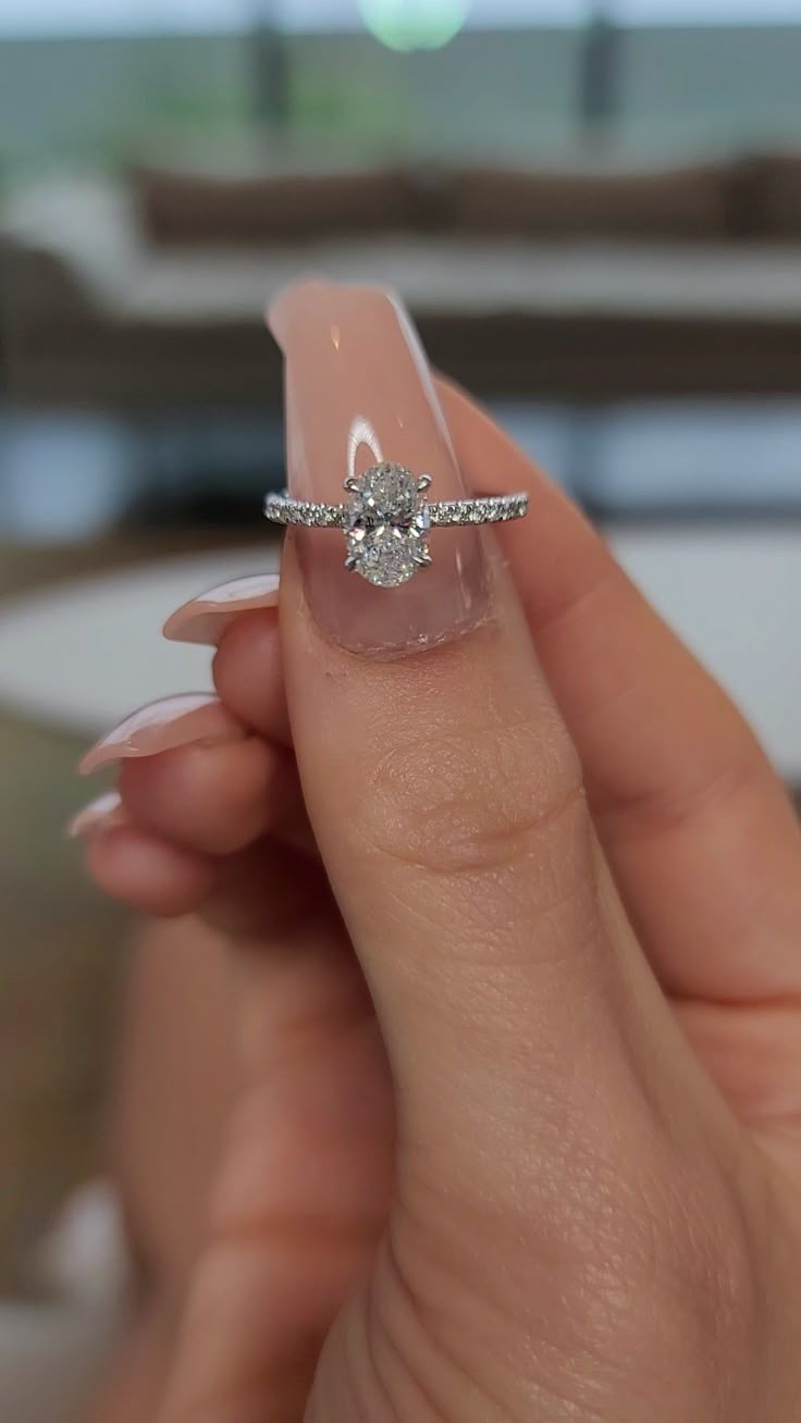 a woman's hand holding a ring with a diamond on it and the words i love carats oval