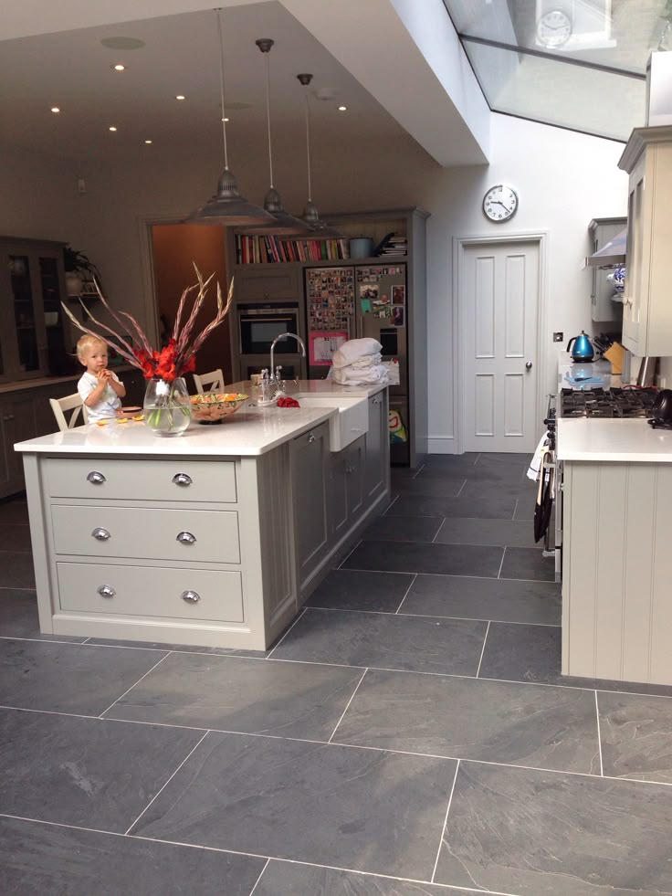 a kitchen with grey tile floors and white cabinets