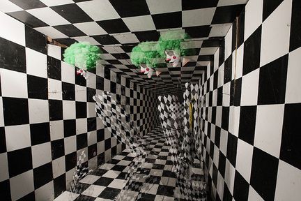 a black and white checkered room with green trees in the center, as if it were an optical illusion