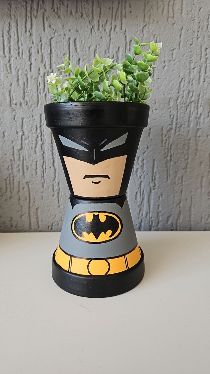 a potted planter with a batman figure on it's head is sitting on a table