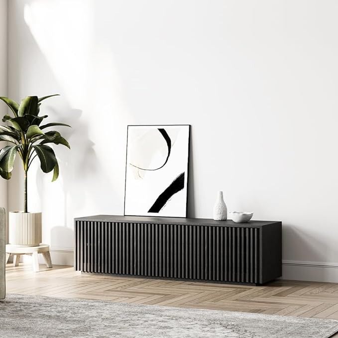 a white room with a plant and pictures on the wall next to an entertainment center