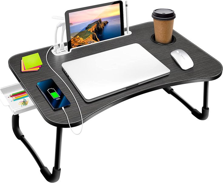 a computer desk with a laptop, mouse and tablet on it