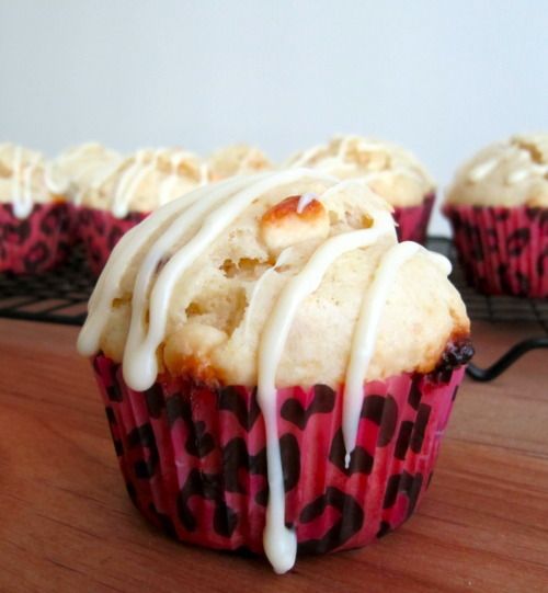 some cupcakes with icing on them sitting on a wooden table next to a cooling rack