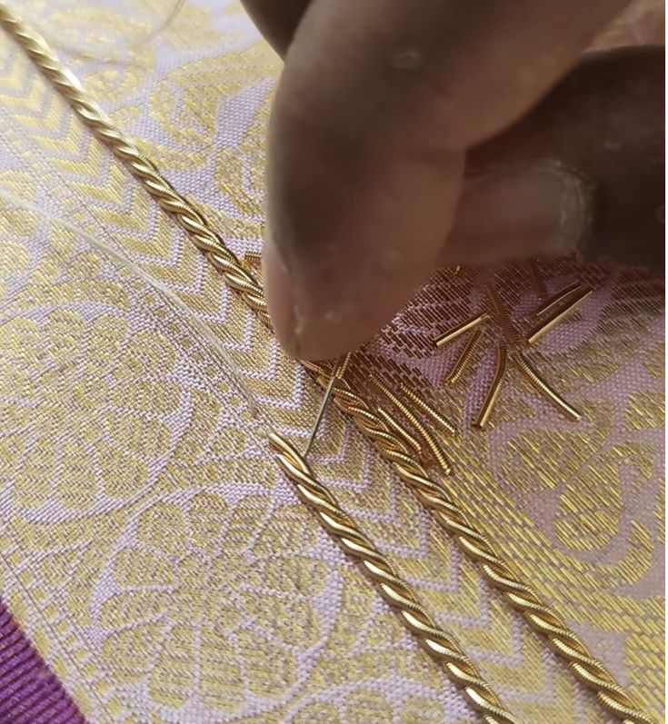 a person is working on some gold chains