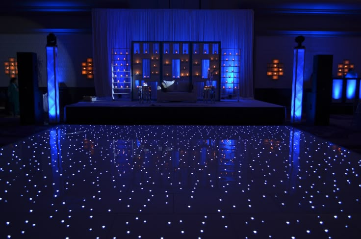 the dance floor is lit up with blue lights