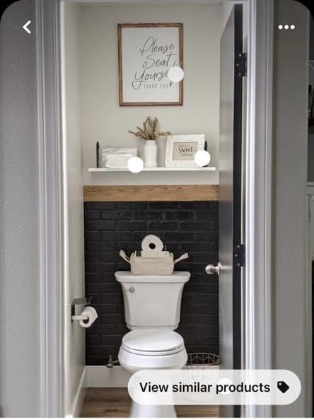 a white toilet sitting in a bathroom next to a wooden shelf with pictures on it