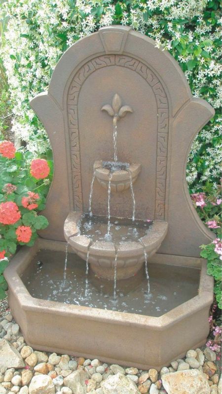 a water fountain with flowers in the background