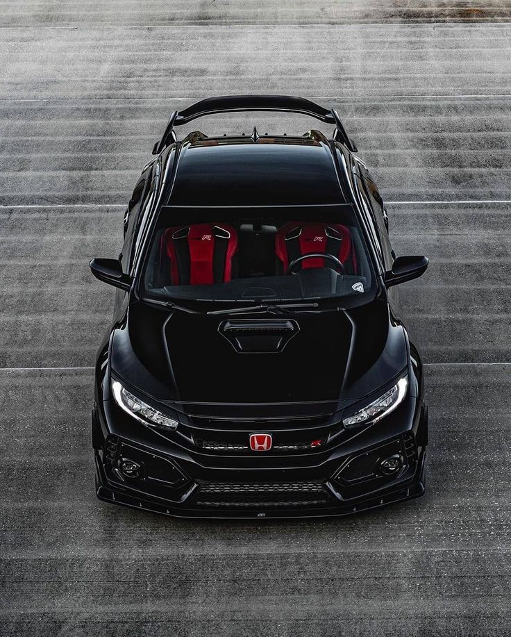 the front end of a black car with red seats in it's trunk and hood