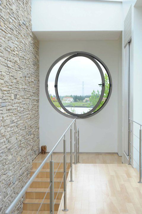 a circular window is in the middle of a room with stairs and railings leading up to it