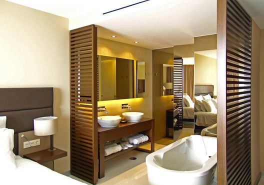 a hotel room with two sinks and a bathtub in the middle of the room