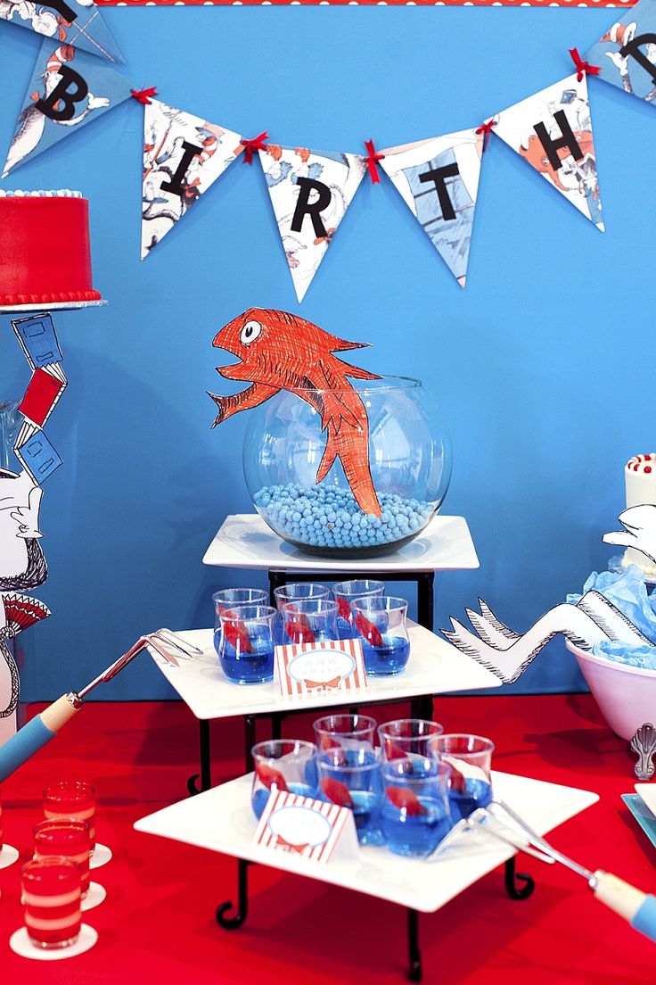 a birthday party with red, white and blue decorations on the wall behind a fish bowl