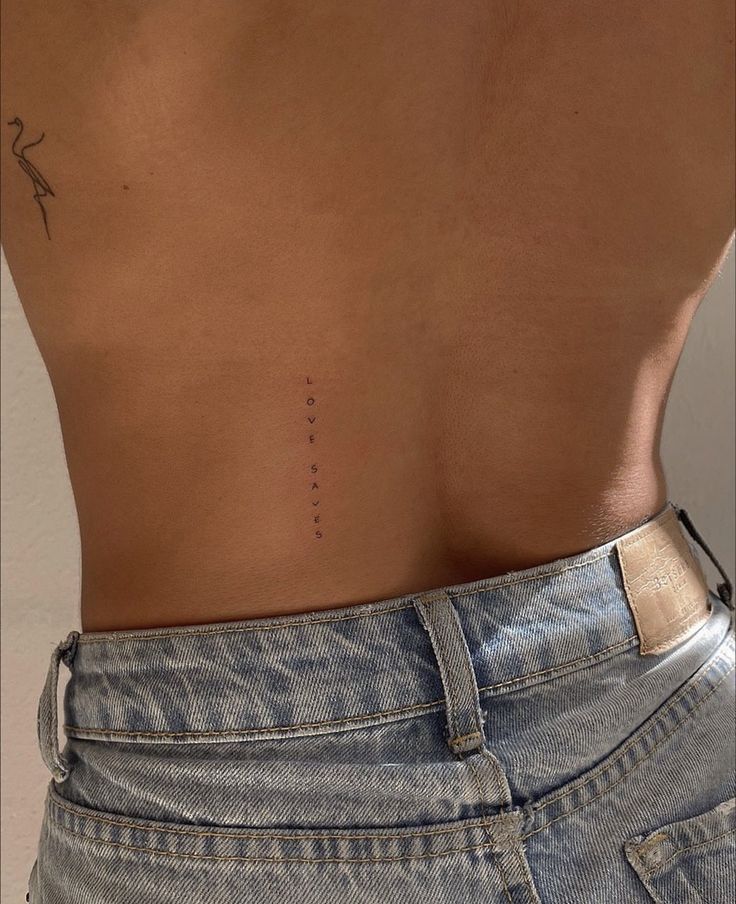 the back of a woman's stomach with an arrow tattoo on her left side