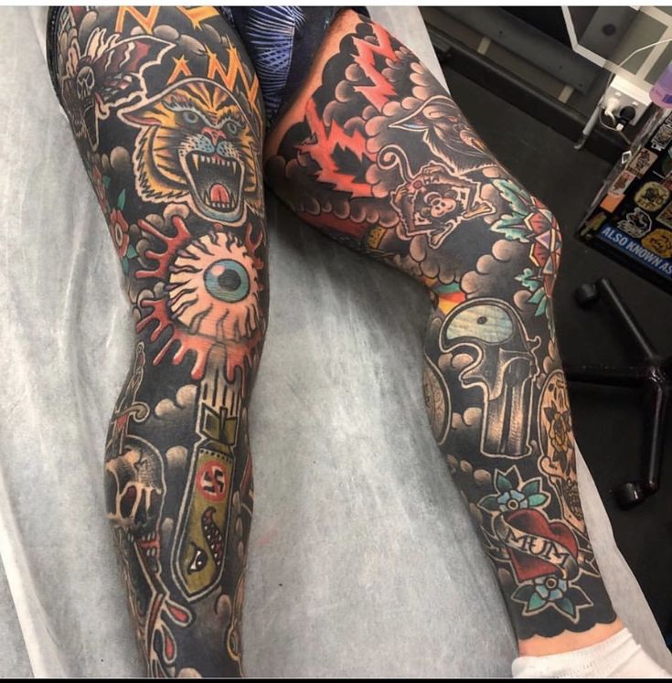 a person with tattoos on their legs laying down