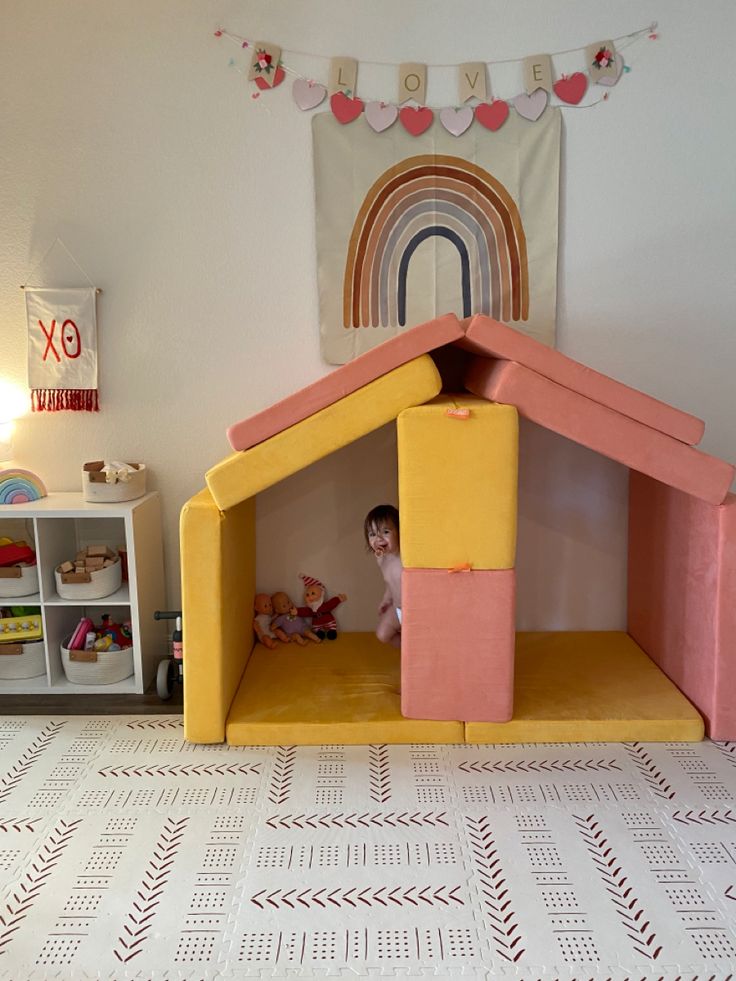 a child's play house made out of foam with a rainbow on the wall