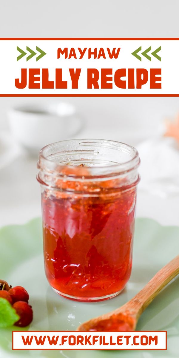 a jar of jelly sits on a plate next to a spoon