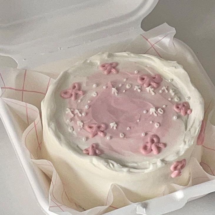 a cake in a white box with pink frosting