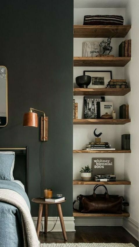 a bed room with a neatly made bed and shelves