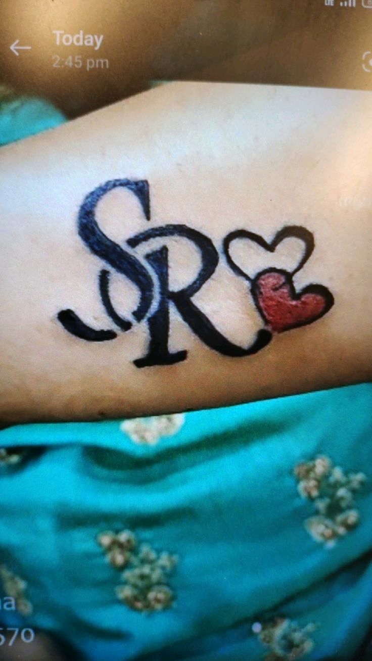 a woman with a tattoo on her arm that says sr and hearts in black ink