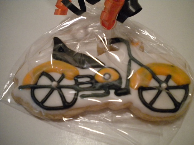 a cookie shaped like a bike with wheels on it's side in a plastic bag