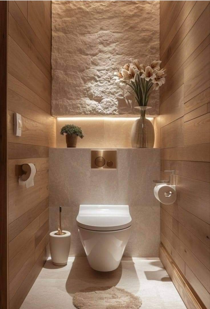 a white toilet sitting inside of a bathroom next to a wooden paneled wall and floor