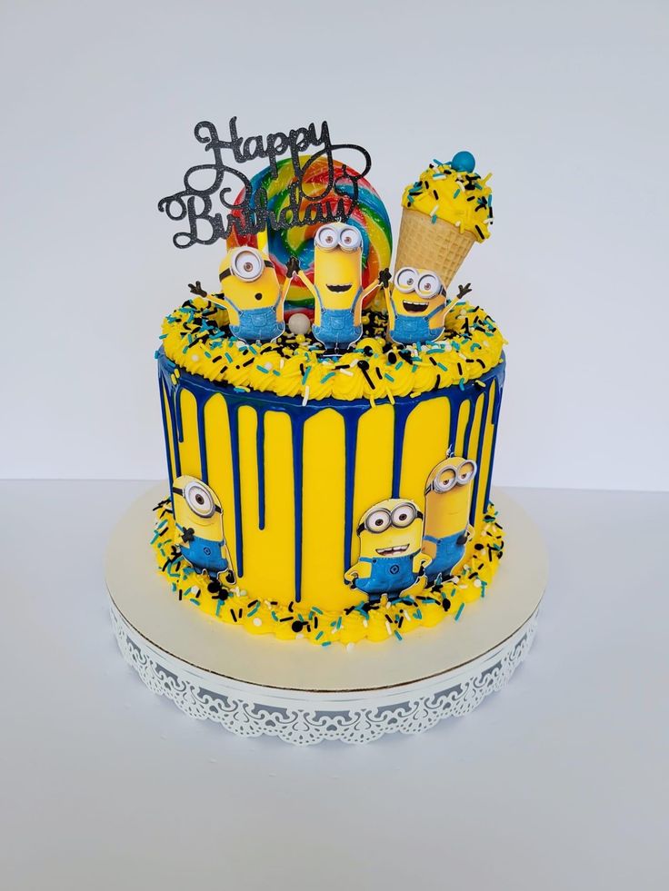 a yellow and blue birthday cake with minion decorations