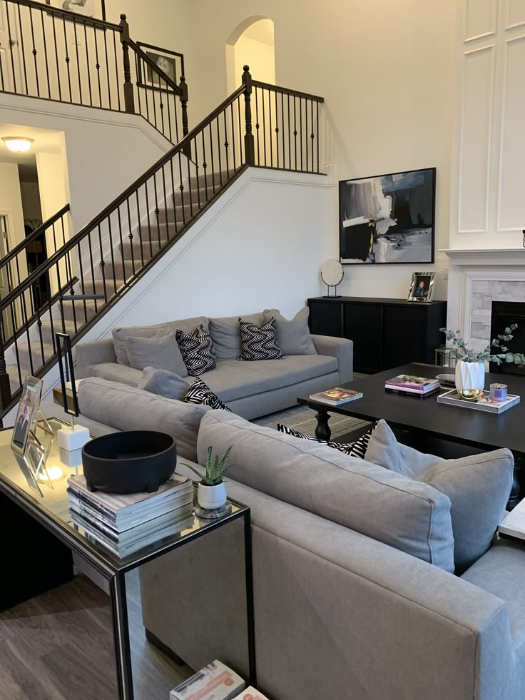 a living room filled with furniture and a staircase leading up to the second floor area