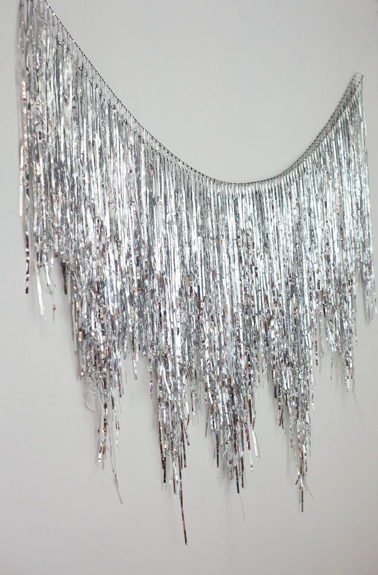 a wall hanging with silver sequins on it's sides and chains attached to the side