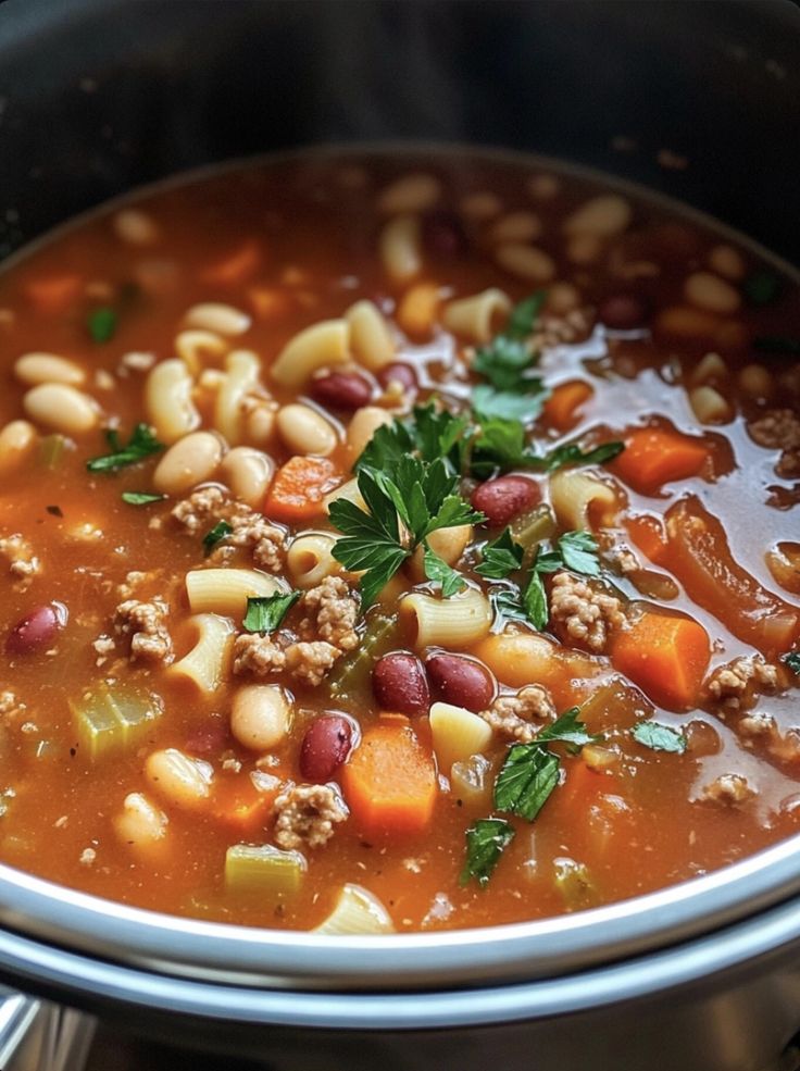 a close up of a bowl of soup with meat and beans